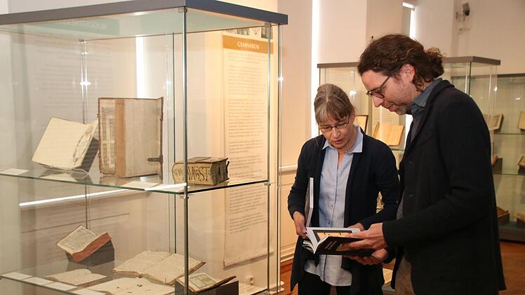 Carolin Oser-Grote und Nicolas Zenzen blättern im Begleitband zur Ausstellung "Geschichte aus dem Buch - Zeitzeugen der Augustinerbibliothek Münnerstadt". Foto: Thomas Malz