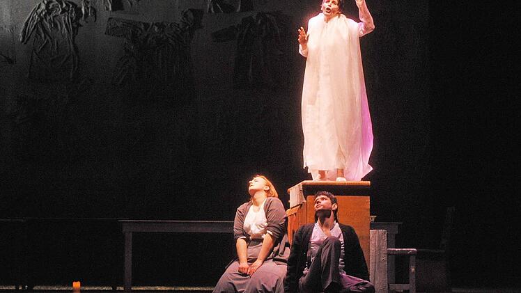 Der "Engel der Geschichte" (Petra Hoffmann) führt die Trauernden ( Kora Pavelic und Jirí Rajniš): Eine stilisierte, poetische Geste, die bei dem eindringlichen szenischen Liederabend des Landestheaters zugleich ins Leid vertieft und darüber hinaus weist.  Foto: Andrea Kremper