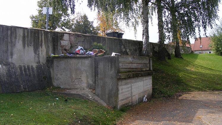 Die nördliche Mauer am Aischer Friedhof und die dort befindliche Müllsammelstelle sind schon seit etlichen Jahren kein Schmuckstück mehr.   Fotos: Mona Lisa Eigenfeld
