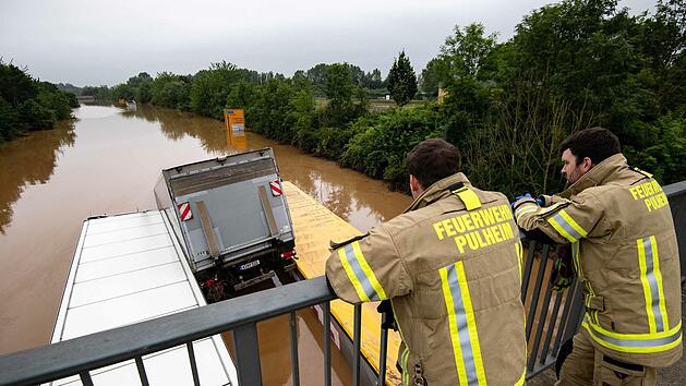 Kein Kanal, sondern eigentlich eine Stra&szlig;e: Feuerwehrleute blicken in Erftstadt in Nordrhein-Westfalen auf die &uuml;berflutete Bundesstra&szlig;e 236.Foto: Marius Becker/dpa