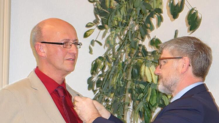 Landrat Michael Busch heftet Xaver Herr die Verdienstmedaille des Verdienstordens der Bundesrepublik Deutschland an.Foto: Lothar Weidner