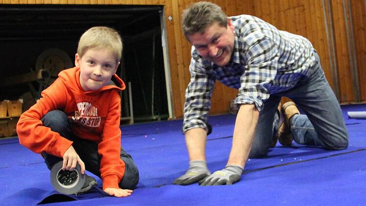 Auch die Jüngsten packen mit an: Jannik Wagner (links) mit Matthias Graß beim Verlegen des Teppichs für den Faschingsball. Fotos: Miriam Hegner