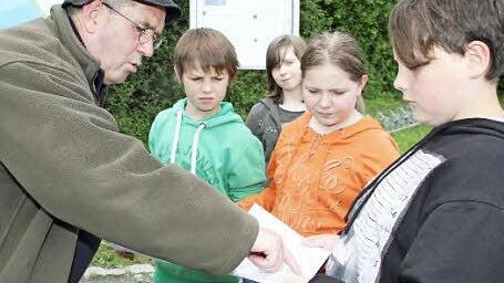 Wo fühlen sich Biber im Landkreis heimisch? Erich Schiffelholz zeigt den Schülern auf einem Lageplan die Reviere. Foto: Dagmar Besand