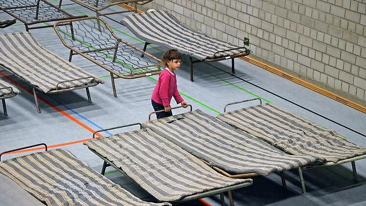 Eines der Kinder, die im Februar in Neustadt aufgenommen wurden, rückt die Betten in der Halle zurecht. Foto: CT-Archiv Rainer Lutz
