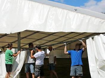 Die Vorbereitungen für das 50-jährige Bestehen der Blaskapelle Neundorf am kommenden Wochenende laufen auf Hochtouren. Am Samstag wurde bereits das große Festzelt auf dem Bolzplatz aufgebaut. Mittendrin: Vorsitzender Andreas Beck (mit hellgrünem T-Shirt)  Foto: Bettina Knauth