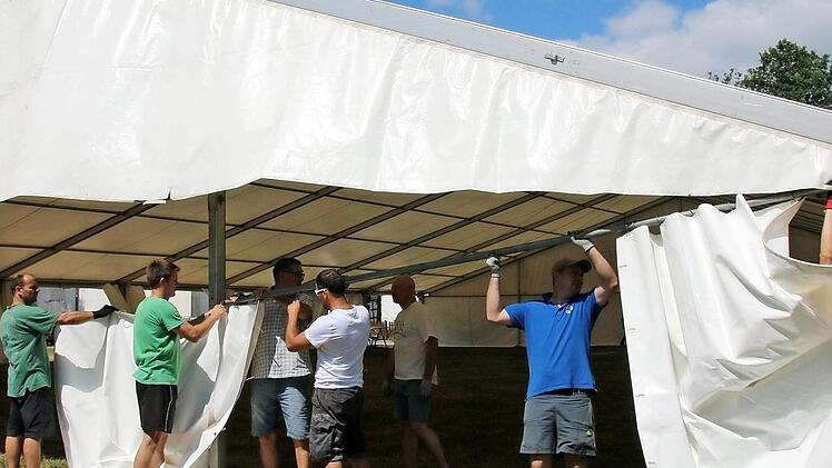Die Vorbereitungen für das 50-jährige Bestehen der Blaskapelle Neundorf am kommenden Wochenende laufen auf Hochtouren. Am Samstag wurde bereits das große Festzelt auf dem Bolzplatz aufgebaut. Mittendrin: Vorsitzender Andreas Beck (mit hellgrünem T-Shirt)  Foto: Bettina Knauth
