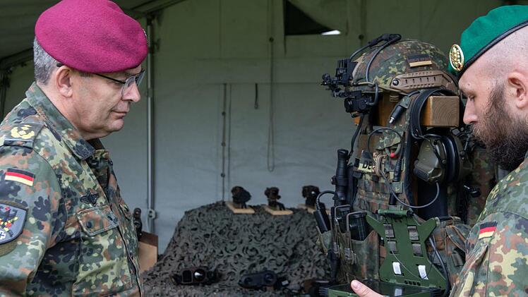 Der Inspekteur des Heeres, Generalleutnant Alfons Mais, lässt sich von einem Soldaten die moderne Kampfausstattung erklären.