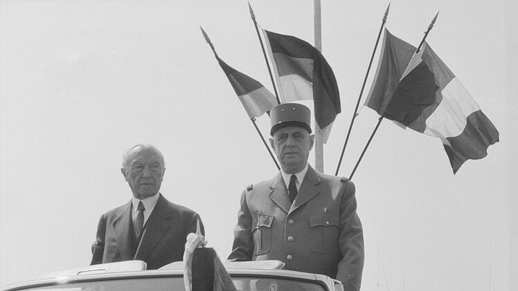 Ein Staatsbesuch als Höhepunkt seines Lebenswerkes: Bundeskanzler Konrad Adenauer und Frankreichs Präsident Charles de Gaulle nehmen 1962 gemeinsam eine Parade ab. Das offizielle Treffen der beiden Staatsmänner ist eine Folge der privaten und politischen Annäherung 1958.