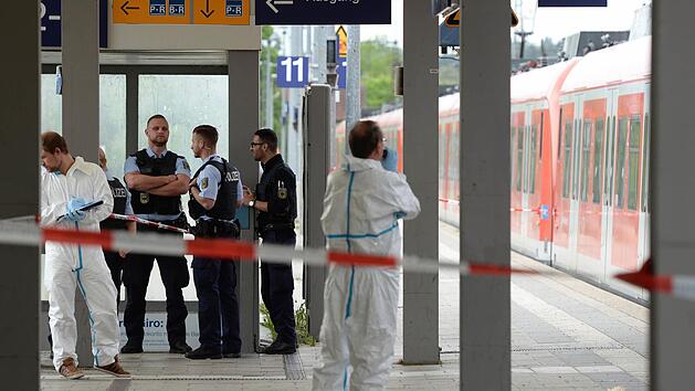 Polizisten stehen am Bahnhof in Grafing bei M&uuml;nchen (Bayern) auf dem Bahnhof und nehmen ihre Ermittlungen auf. Foto: Andreas Gebert/dpa