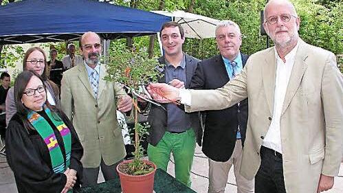 Pfarrerin Margit Glöckner-Wenk, Kita-Leiterin Astrid Schmidt, Lutz Langenstein, Matthias Emmer, Oberbürgermeister Norbert Tessmer und Architekt Christoph Gatz (von links) binden die guten Wünschen für Kinder und Mitarbeiter an das Bäumchen.  Fotos: Bernd Brückner