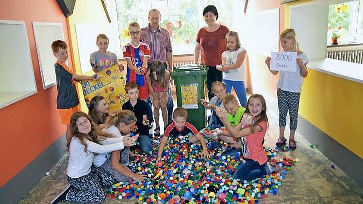 Stolz präsentieren Schüler der Grundschule Stockheim ihre Sammlung von 8000 Plastikdeckeln, mit denen sie Schluckimpfungen für an Polio erkrankte Kinder finanzieren. Mit im Bild: Förderlehrer Siegbert Jakob und Rektorin Astrid Kestel Foto: Karl-Heinz Hofmann