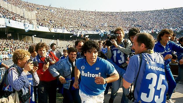 Dokumentarfilm "Diego Maradona" zum f&uuml;nften Todestag: Der Superstar l&auml;uft von Fotografen umringt in Neapels San-Paolo-Stadion ein.