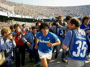 Dokumentarfilm "Diego Maradona" zum f&uuml;nften Todestag: Der Superstar l&auml;uft von Fotografen umringt in Neapels San-Paolo-Stadion ein.