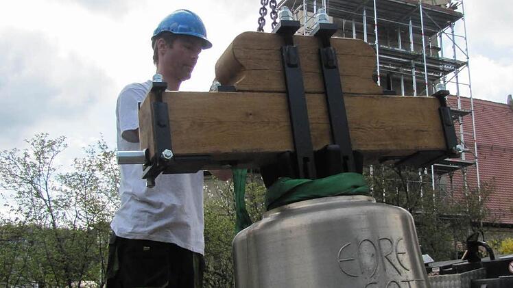 Thorsten Riedel von der Fa. Bayreuther Turmuhren vertäut die neuen Glocken, bevor sie von einem Kran auf den Seidmannsdorfer Kirchturm gehievt werden. Foto: Martin Koch