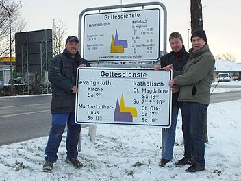 Kirchenrat Walter Drebinger, Pfarrgemeinderat Manfred Welker und Kirchenrat Thomas Kotzer (v. l.) zeigen vor dem neuen Schild das alte Exemplar. Foto: privat