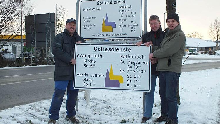 Kirchenrat Walter Drebinger, Pfarrgemeinderat Manfred Welker und Kirchenrat Thomas Kotzer (v. l.) zeigen vor dem neuen Schild das alte Exemplar. Foto: privat