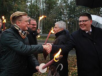 Der Vorsitzende der Jungen Union Coburg Maximilian Forkel und der Kreisvorsitzende der CDU Sonneberg Danny Dobmeier begr&uuml;&szlig;en sich an der "Gebrannten Br&uuml;cke". Im Hintergrund ist Festredner Roland Jahn zu sehen. Fotos: Jannik Reutlinger
