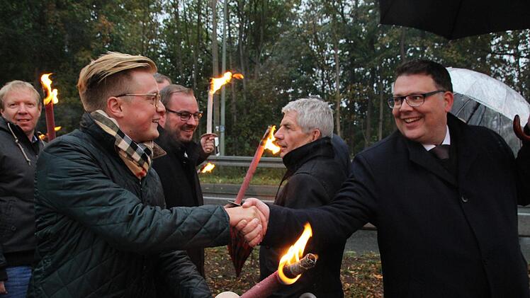 Der Vorsitzende der Jungen Union Coburg Maximilian Forkel und der Kreisvorsitzende der CDU Sonneberg Danny Dobmeier begr&uuml;&szlig;en sich an der "Gebrannten Br&uuml;cke". Im Hintergrund ist Festredner Roland Jahn zu sehen. Fotos: Jannik Reutlinger