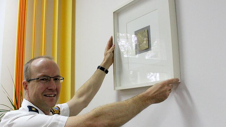Ein ganz besonderes Erinnerungsstück hat Ralf Neumüller hinter seinem Schreibtisch aufgehängt: Die goldfarbene Fliese des Künstlers Joseph Michael Neustifter erinnert an Neumüllers Einsatz beim Papst-Besuch im Jahre 2006.Ulrike Nauer