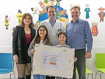 Stellvertretend f&uuml;r alle Kinder der F&uuml;rther &bdquo;Villa Kunterbunt&ldquo; &uuml;berreichten die beiden Viertkl&auml;sslerinnen Mina (l.) und Emma den symbolischen Spendenscheck an Professor Markus Metzler (Kinderonkologie Uniklinikum Erlangen). Soultana Papadopulos (L...