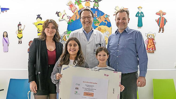 Stellvertretend f&uuml;r alle Kinder der F&uuml;rther &bdquo;Villa Kunterbunt&ldquo; &uuml;berreichten die beiden Viertkl&auml;sslerinnen Mina (l.) und Emma den symbolischen Spendenscheck an Professor Markus Metzler (Kinderonkologie Uniklinikum Erlangen). Soultana Papadopulos (L...
