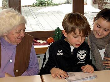 Gunda Querfurth freut sich über die Weihnachtsgeschichte, die ihr Luisa Förtsch (rechts) und Janis Backer vorlesen. Foto: Susanne Deuerling