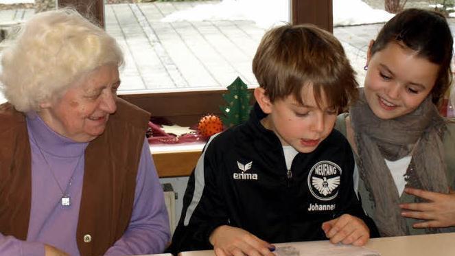 Gunda Querfurth freut sich über die Weihnachtsgeschichte, die ihr Luisa Förtsch (rechts) und Janis Backer vorlesen. Foto: Susanne Deuerling