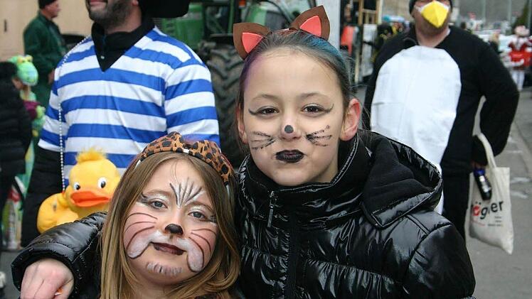Zwei schnurrende Katzen feiern Fasching.
