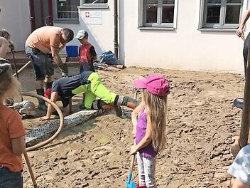 Nachdem der Hof des Kindergartens in Gädheim von Schlamm bedeckt war, kamen schnell Feuerwehr und Nachbarn zu Hilfe. Foto: Peter Kraus