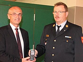 Der Digitalfunk war eines der beherrschenden Themen beim Kreisfeuerwehrtag. Landrat Wilhelm Schneider (links) übergab an seinen Kreisbrandrat Ralf Dressel (rechts) ein Handsprechfunkgerät. Foto: Helmut Will