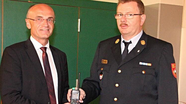 Der Digitalfunk war eines der beherrschenden Themen beim Kreisfeuerwehrtag. Landrat Wilhelm Schneider (links) übergab an seinen Kreisbrandrat Ralf Dressel (rechts) ein Handsprechfunkgerät. Foto: Helmut Will