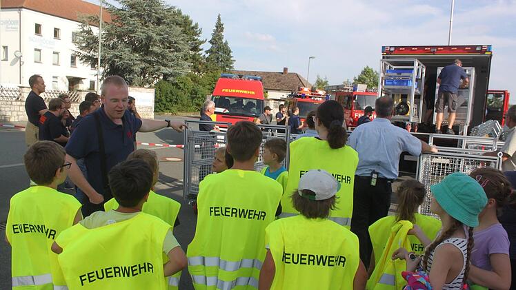 Holger Reinlein (links) erklärt dem Feuerwehrnachwuchs, bei welchen Ereignissen das neue Fahrzeug eingesetzt wird und was darauf verlastet ist.  Foto: Matthias Einwag