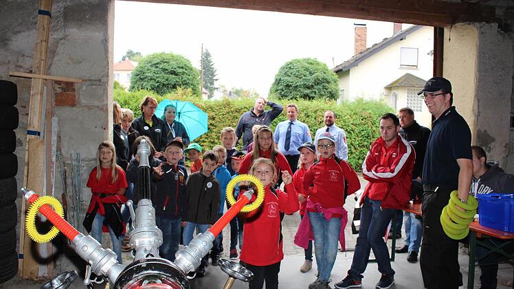 Da braucht es Zielwasser: Der Ring soll an der "zehnarmigen Krake” hängen bleiben. Im Hintergrund verfolgen die Reichmannsdorfer Kommandanten Otmar Söllmann und Jochen Stark (von rechts) das Geschehen. Fotos: Evi Seeger
