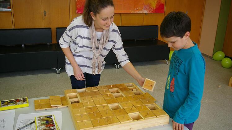Holz zum Anfassen, Holz zum Spielen. In der "Kinder- und Mitmachwerkstatt suchen Bastian und Hannah beim Holz-Memory die Felder mit denselben Inhalten.