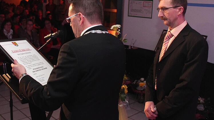 Bürgermeister Karsten Fischkal liest dem Bürgermedaillenträger Egidius Dobeneck den Wortlaut der Urkunde vor