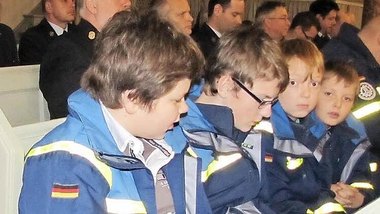 Andächtig nehmen Frederic Beil, Hinnerk Flessa, sowie die beiden Brüder Louis und Matthis Müller von der THW-Jugend am Gottesdienst der Notfallseelsorge in der Heilig-Kreuz-Kirche teil. I Foto: Martin Koch