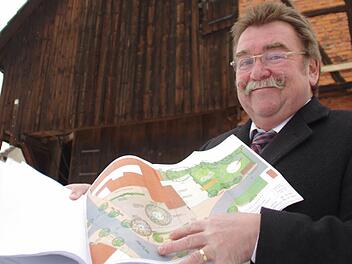 Josef Geiger mit den Plänen für die bald entstehende Dorfscheune (im Hintergrund). Foto: Marco Meißner