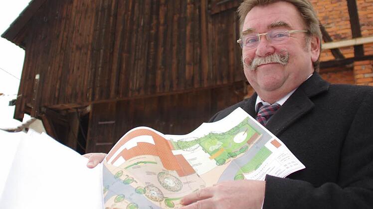 Josef Geiger mit den Plänen für die bald entstehende Dorfscheune (im Hintergrund). Foto: Marco Meißner