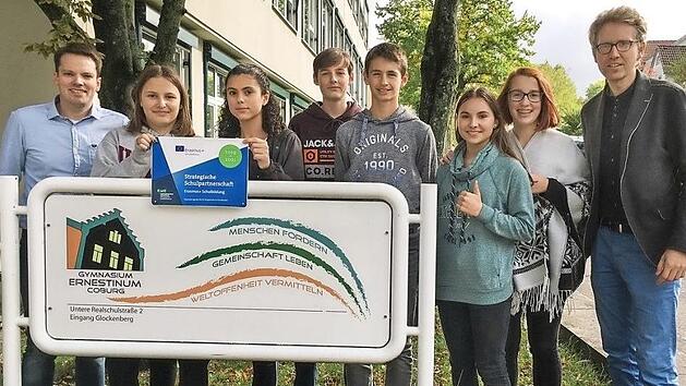 Die Projektleiter Erik Hüneburg (rechts) und Tillmann Leibing (links) präsentieren mit teilnehmenden Schülern das offizielle Schild, das künftig am Eingang des Ernestinums auf das europäische Kooperationsprojekt hinweisen wird.  Foto: Bernd Jakob