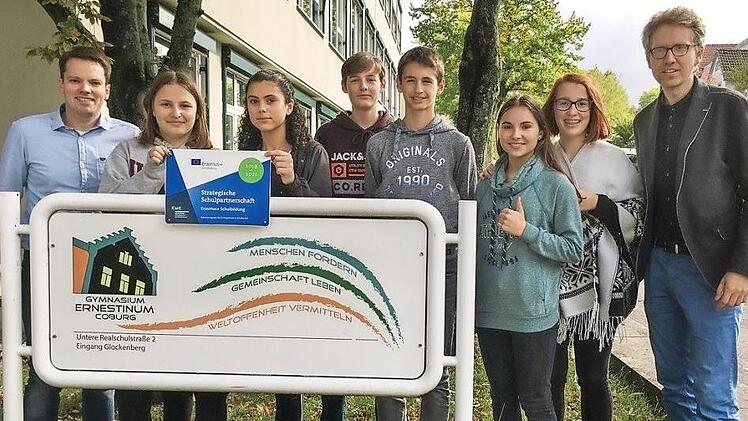 Die Projektleiter Erik Hüneburg (rechts) und Tillmann Leibing (links) präsentieren mit teilnehmenden Schülern das offizielle Schild, das künftig am Eingang des Ernestinums auf das europäische Kooperationsprojekt hinweisen wird.  Foto: Bernd Jakob