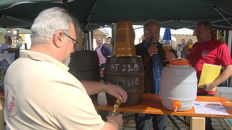 Auf reges Interesse stieß die Verkostung von fünf Bieren aus dem Rodachtal, die Biersommelier Markus Raupach (Mitte) auf Einladung der Initiative Rodachtal am Samstag beim Brauhausfest in Unterelldorf anbot. Als erstes wurde das Hausbräu aus dem Seßlacher Kommunbrauhaus vorgestellt. Während Helfried Schleicher vom gastgebenden Brautraditionsverein das Bier einschenkte, erläuterte Stefan Pachsteffl (rechts) die Eigenschaften des Kommunbräus. Foto: Bettina Knauth