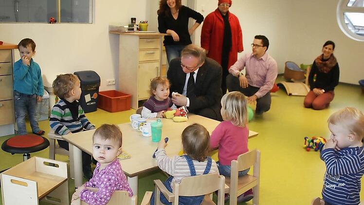 Der Maria-Stern-Kindergarten in Hausen wurde umfassend saniert und vergrößert. Für die Kinderkrippe wurde das Gebäude aufgestockt. Viel Lob gab es von Dekan Thomas Keßler (bei den Kindern). Hinten Kirstin Scherner (links) und Architekt Stephan Scharf (kniend).  Foto: Bartl