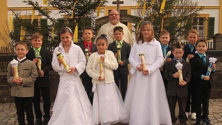 Kirchlauter &mdash;  Drei M&auml;dchen und acht Buben gingen in Kirchlauter zum ersten Male zum Tisch des Herrn. Unser Bild zeigt die Erstkommunikanten am Pfarrhaus mit Pfarrer Martin Wissel. Foto: G&uuml;nther Geiling