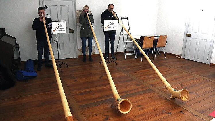 Drei der vier Mitglieder der Gruppe "Lauertaler Alphornbläser" spielten  beim offiziellen Start des Adventskalenders im Münnerstädter Heimatspielhaus. Foto:  Dieter Britz