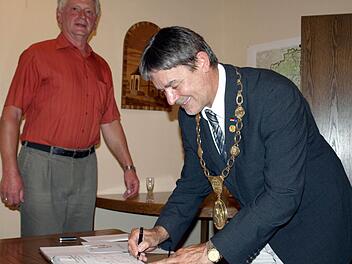 Als neuer Träger der Goldenen Ehrennadel trägt sich Gerhard Wunder ins Goldene Buch des Marktes Steinwiesen ein. Mit im Bild Zweiter Bürgermeister Bruno Beierlorzer.