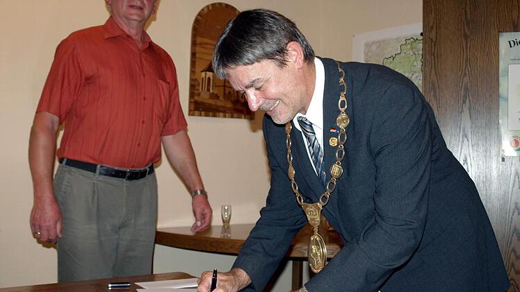 Als neuer Träger der Goldenen Ehrennadel trägt sich Gerhard Wunder ins Goldene Buch des Marktes Steinwiesen ein. Mit im Bild Zweiter Bürgermeister Bruno Beierlorzer.