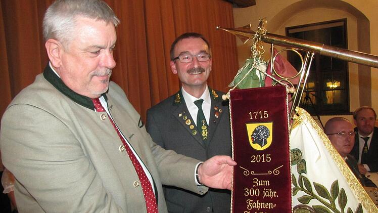 Die Traditionsfahne der Coburger Schützen ist 300 Jahre alt. Zum Jubiläum spendierte die Stadt Coburg ein neues Fahnenband, das Oberbürgermeister Norbert Tessmer bei der Königstafel gleich befestigte. Foto: Martin Koch