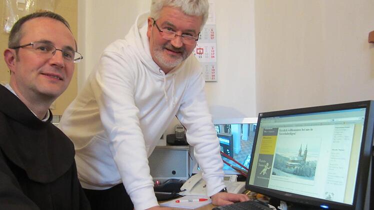 Pater Christoph Kreitmeir (rechts) und Bruder Klaus Steinbüchl schauen sich am PC die neu gestaltete Homepage des Franziskanerklosters Vierzehnheiligen an. Seit wenigen Tagen können auch Besitzer von Smartphones und Tablets darauf gut navigieren. Foto: Matthias Einwag