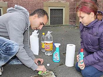 Gründlich putzen: Joachim Lopez und Ella Zurek knien vor den Stolpersteinen am Jüdischen Gemeindehaus.  Fotos: Sabine Herteux
