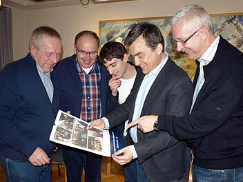 Interessiert betrachten Bürgermeister Jens Korn (Zweiter von rechts), Franz Behrschmidt (rechts) und (von links) Michael Förner, Dieter Müller und Thomas Weiß den neuen Wallenfelser Heimatkalender "Hinaus in die weite Welt".